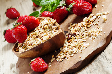 Homemade baked muesli with fresh strawberries and mint in a bowl