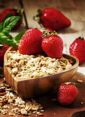 Homemade baked muesli with fresh strawberries and mint in a bowl