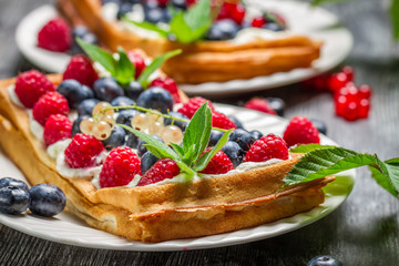 Closeup of waffels with cream, blueberry and raspberry
