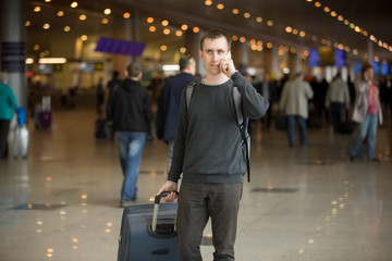 Young traveler in airport making call