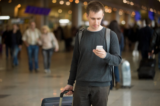 Young traveler using mobile phone in airport