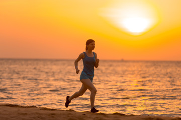 Fototapeta na wymiar Young woman jogging at sunrise
