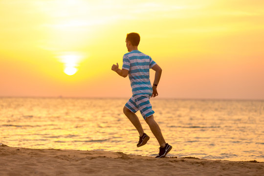 Young man jogging at the sea coast