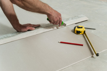 Man cuts off a piece of drywall