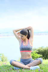 Young fitness woman doing stretching exercises outside