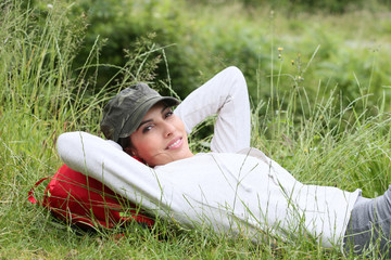 Young woman relaxing in grass on hiking day