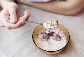 woman eating cereal with milk, close-up hands