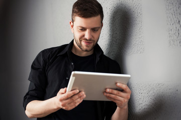 Man with tablet by the wall
