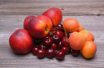 Naklejka na ściany i meble Nectarines, cherries and apricots on wooden table