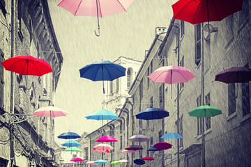Fototapeta na wymiar Vintage filtered umbrellas hanging above street.