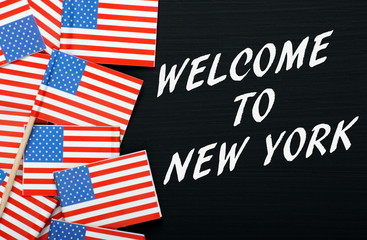 Welcome To New York on a blackboard with USA flags