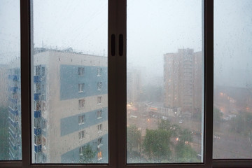 Fototapeta na wymiar raindrops on urban house wndow during rain
