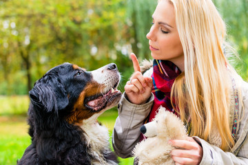 Frau bei Hundetraining mit Hund draußen im Park