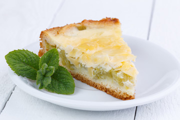 Slice of rhubarb pie on wooden table.