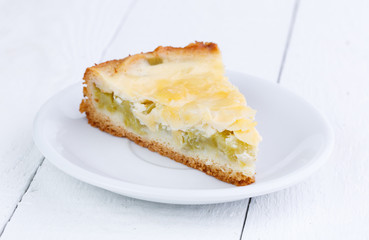 Slice of rhubarb pie on wooden table.