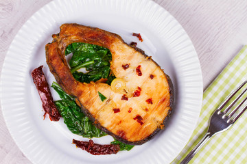 Broiled fish with dried tomatoes and spinach