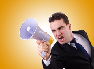 Young businessman with loudspeaker on white