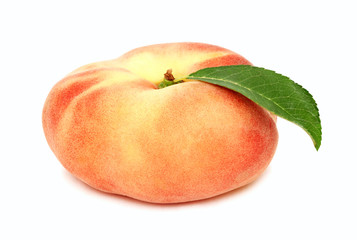 One whole flat peach with green leaf (isolated)
