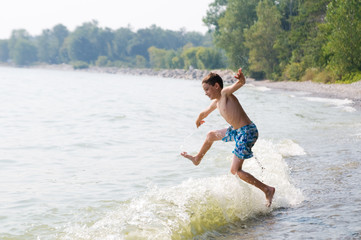 Fototapeta premium young boy playing in the waves at a beach