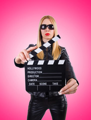 Woman with movie clapper on white