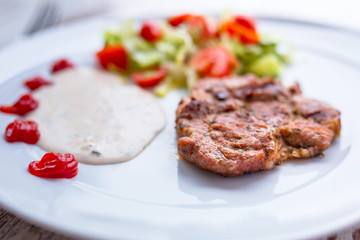 Grilled pork steak with salad on the plate