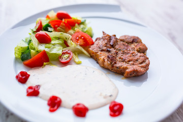 Grilled pork steak with salad on the plate