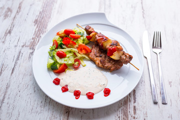 Grilled duck shashlik with salad on the plate