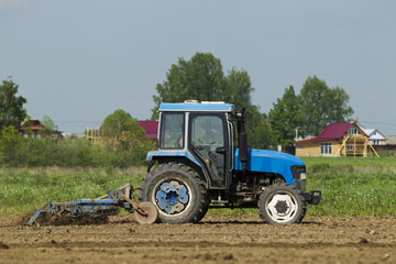 The tractor in the field on agricultural operations.