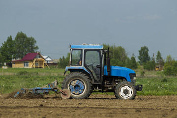 The tractor in the field on agricultural operations.