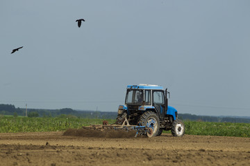 The tractor in the field on agricultural operations.