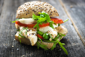 Chicken sandwich with crispy baguette  on a wooden background 