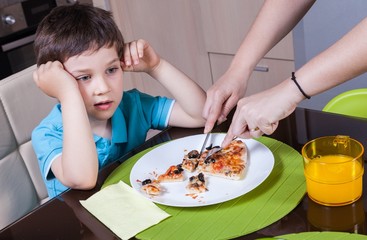 Obraz na płótnie Canvas Mother who cut off her son's pizza