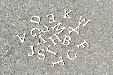 アスファルトの地面におかれたアルファベット