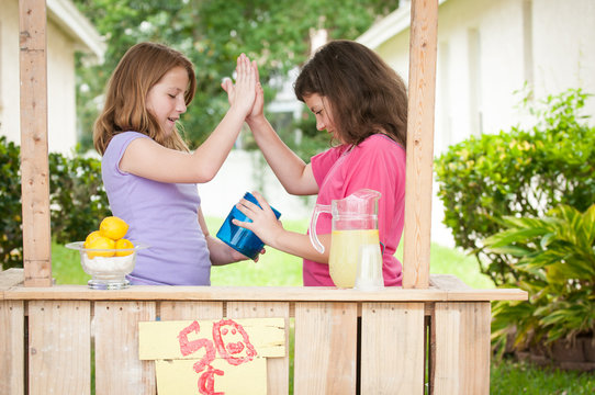 Young girls with a money bucket giving a high five