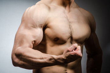 Muscular man posing in dark studio