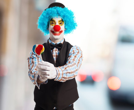 portrait of a funny clown holding a lollipop