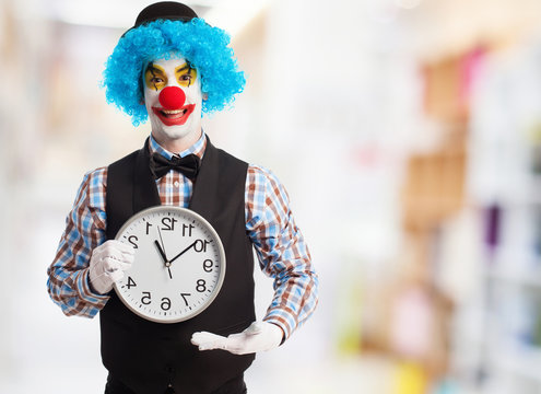 portrait of a funny clown holding a clock