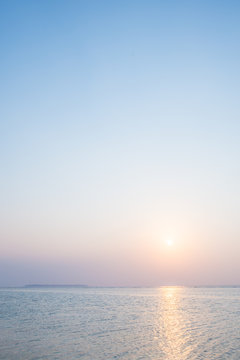 沖縄の海・夕日と淡い空