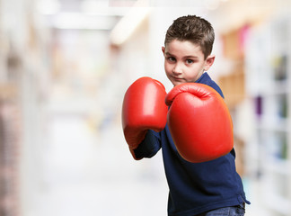 little kid fighting with red boxing gloves