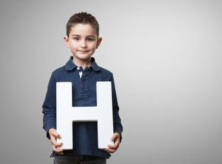 little kid holding the h letter