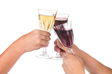 Hands toasting red and white wine in crystal glasses