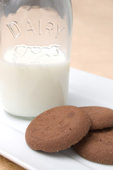Cookies and Milk Bottle on a Golden Table Top