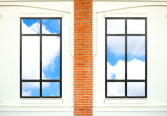 house window with brick post and reflection of nice blue sky