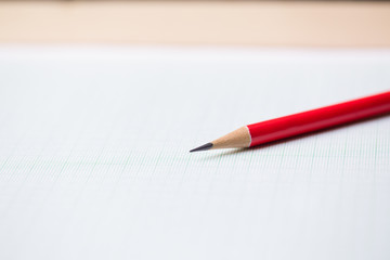 close-up red pencil on graph paper background