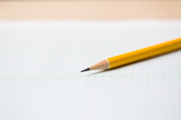 close-up yellow pencil on graph paper background
