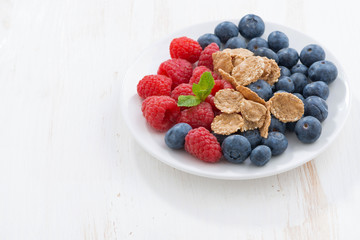 blueberries, raspberries and wholegrain flakes on white 