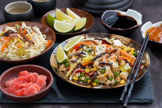 asian lunch - fried rice with tofu and vegetables on dark table