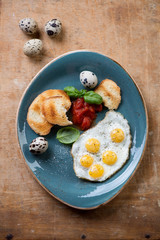 Breakfast fried eggs and toasts, rustic wooden surface, top view