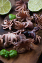 Close-up of baby octopuses with lime and basil, selective focus
