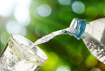  Drinkwater wordt uit een fles in een glas gegoten © Love the wind
